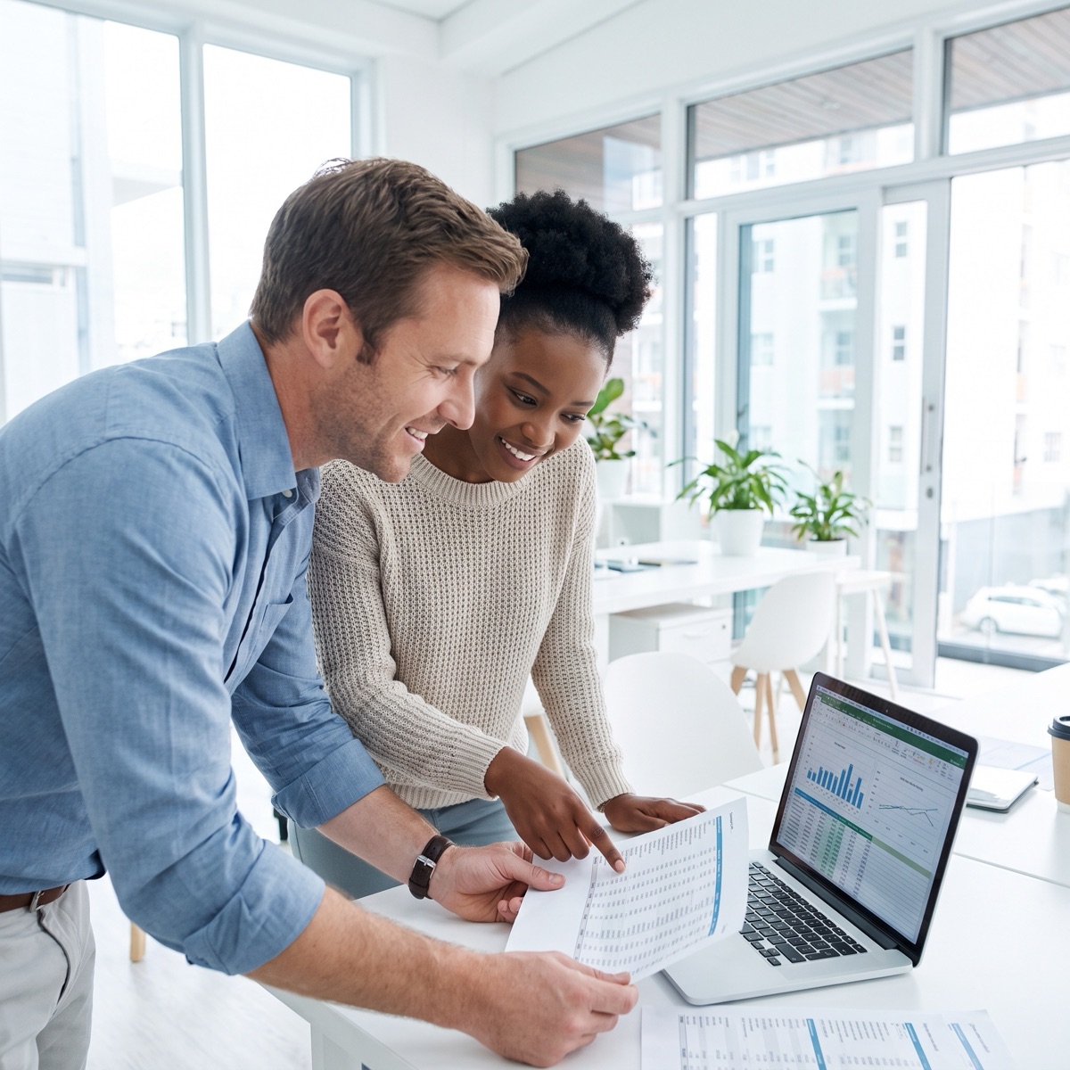 Two colleagues reviewing compensation data together on a laptop