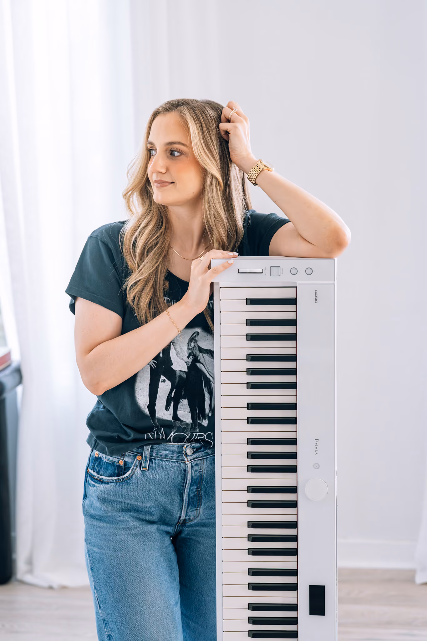 Kaitlyn sitting at a digital piano beside a Piano Accelerator sign