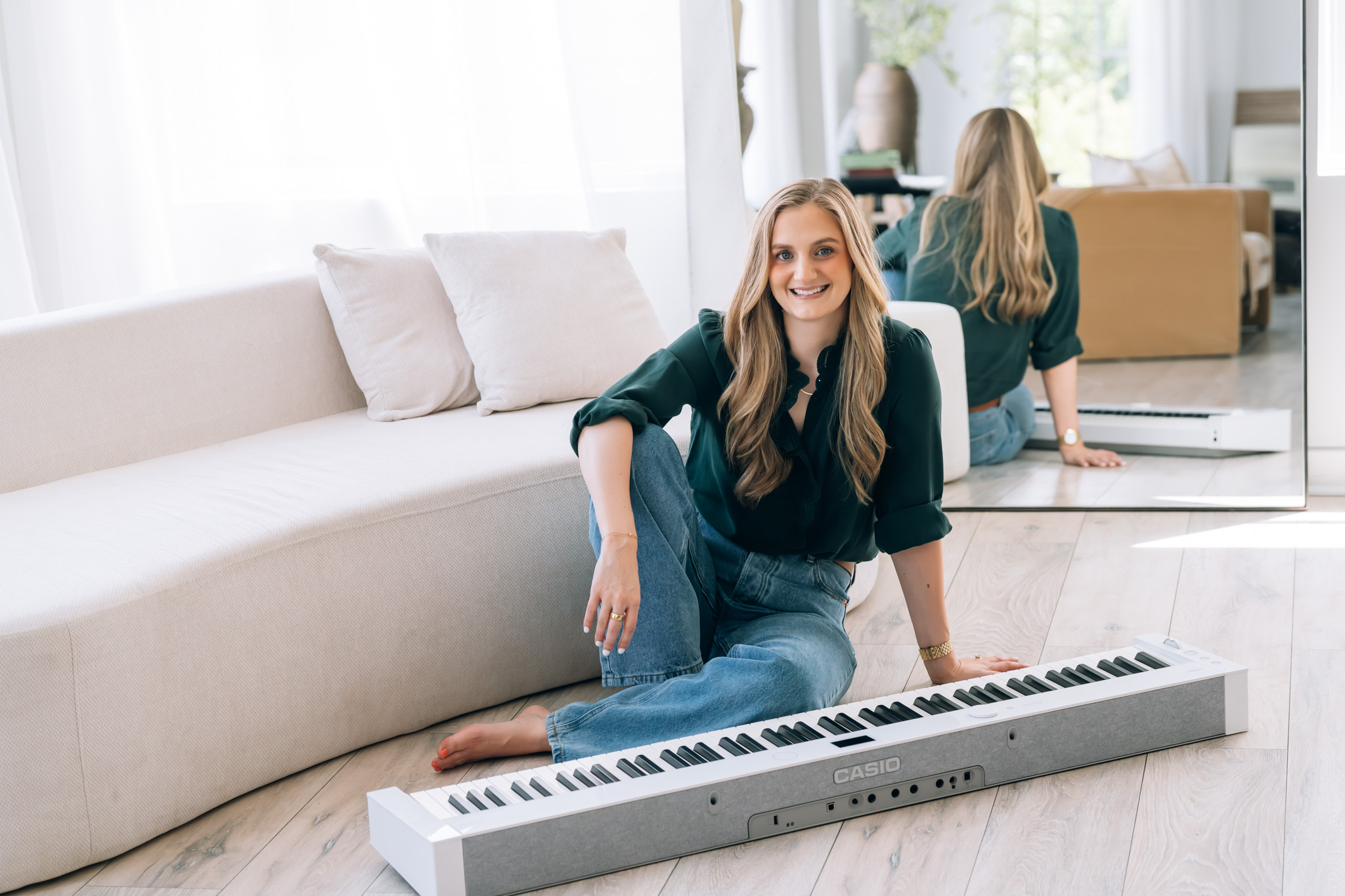 Kaitlyn sitting on the floor beside a white keyboard