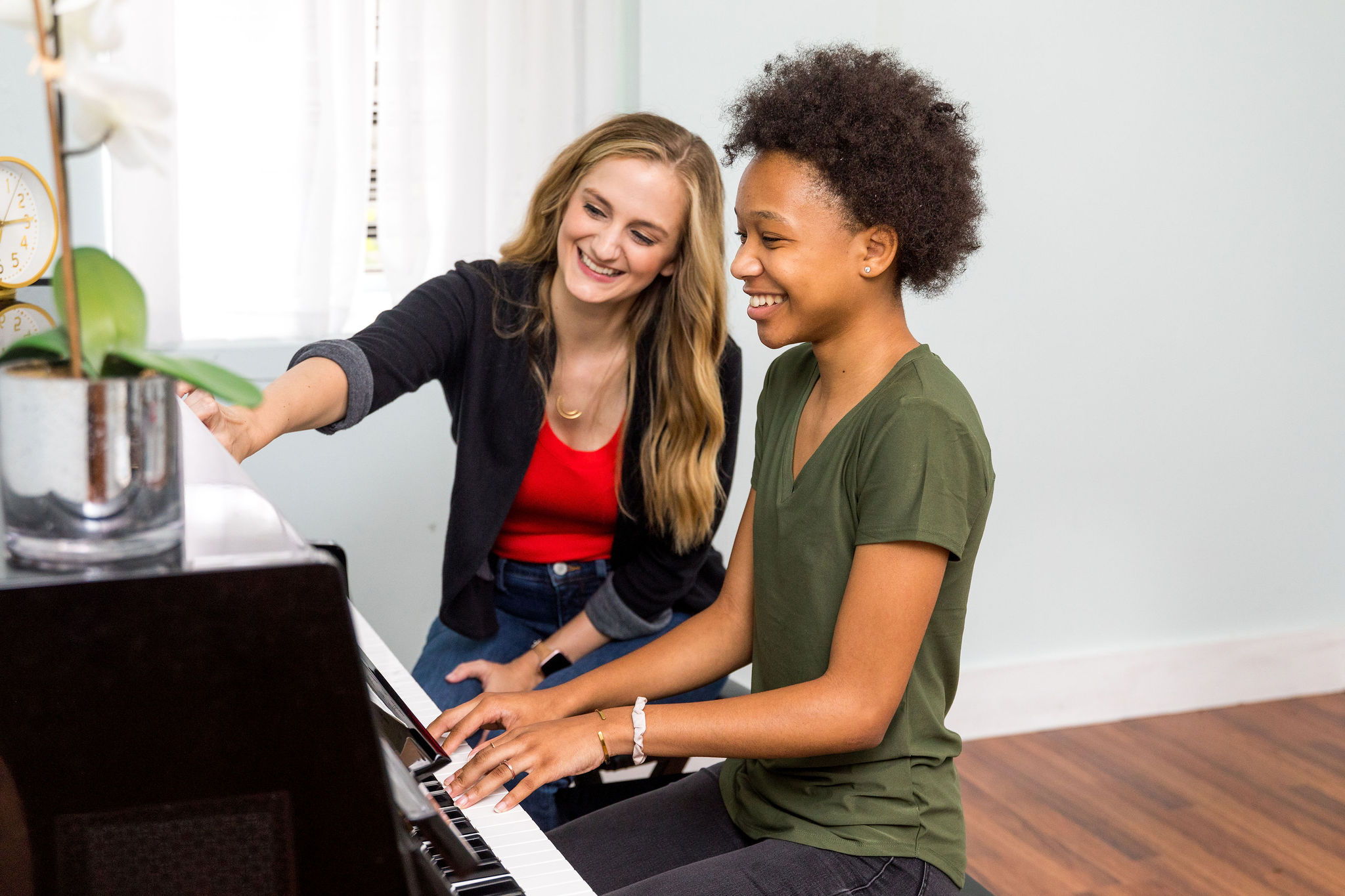 Kaitlyn teaching a student at the piano