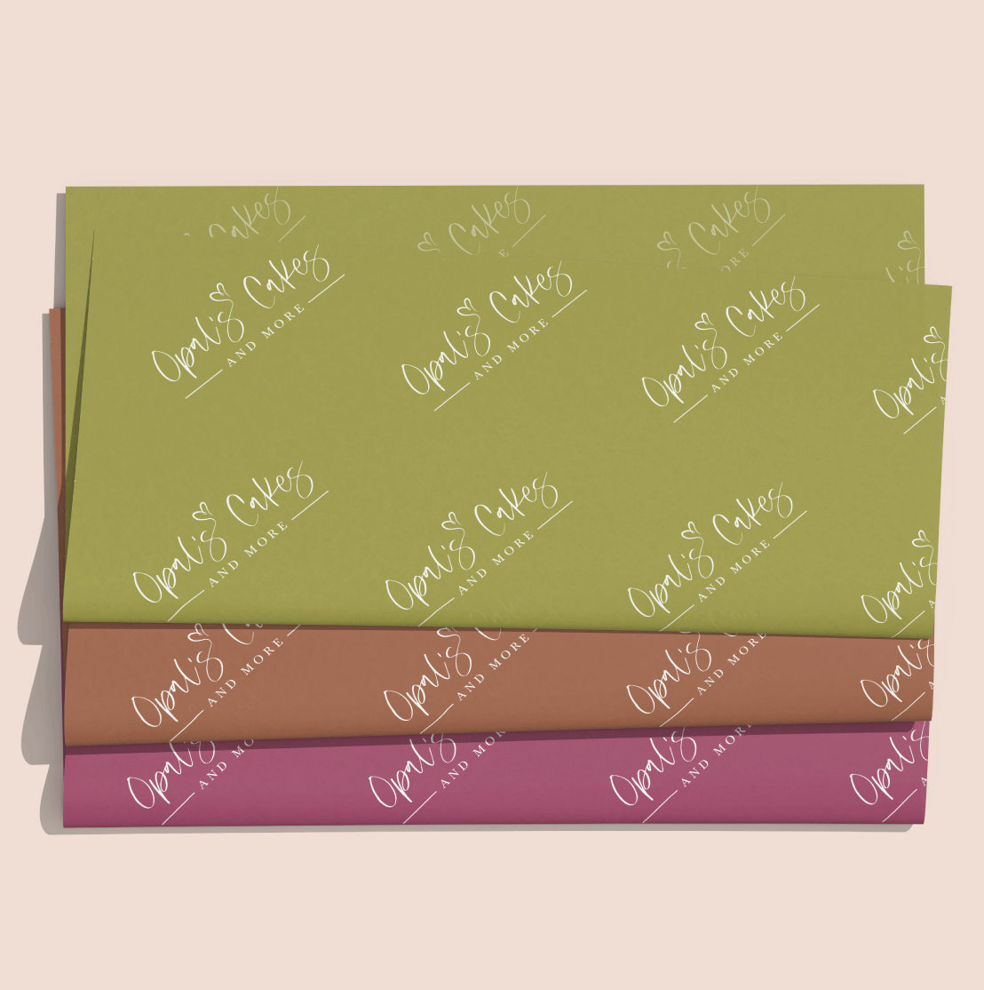 3 packaging tissues, each in a different brand color. Each have a step and repeat pattern of the Opal's Cakes and More logo.