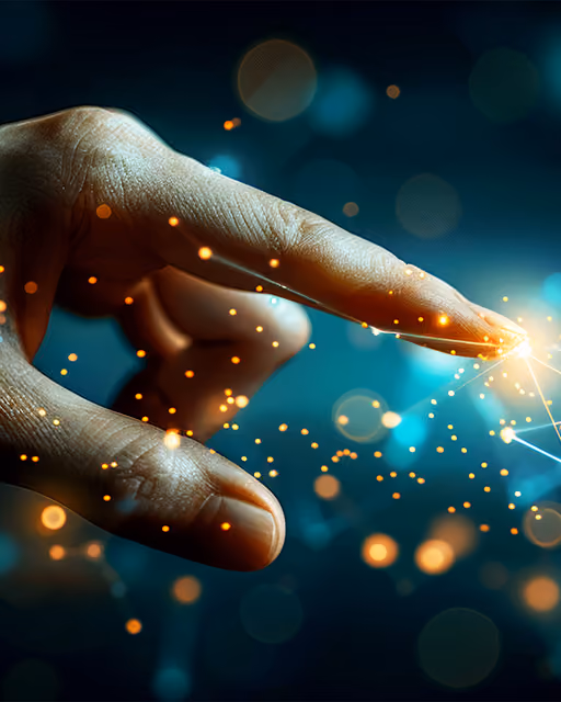 Hand with extended index finger touching a glowing point with scattered light particles around it.