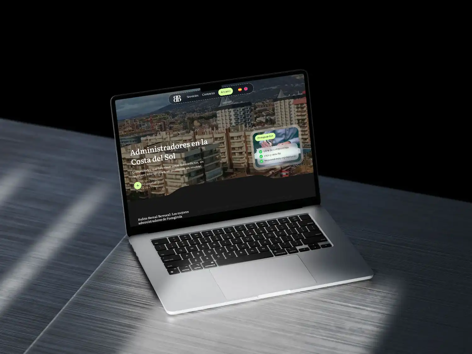 MacBook sobre una superficie metálica mostrando la web de Bufete Bernal Berrocal