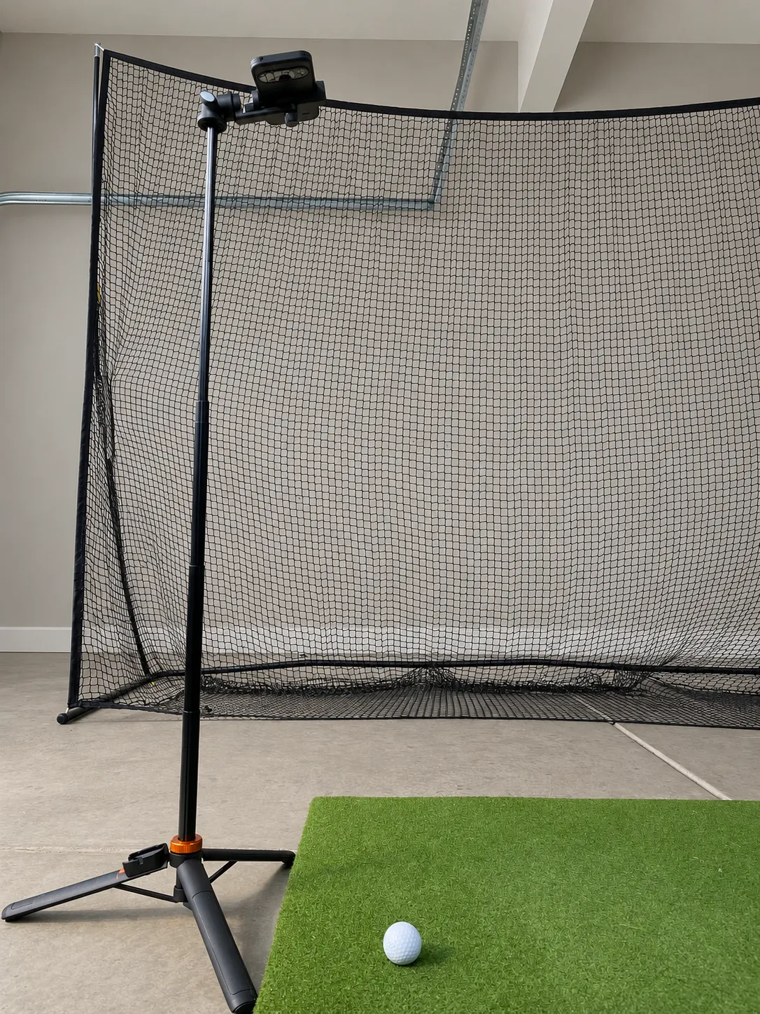 A phone mounted above a golf ball with its rear camera facing down toward a practice mat.