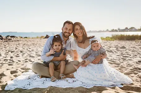 Dr. Nithya with her husband and two children at the beach