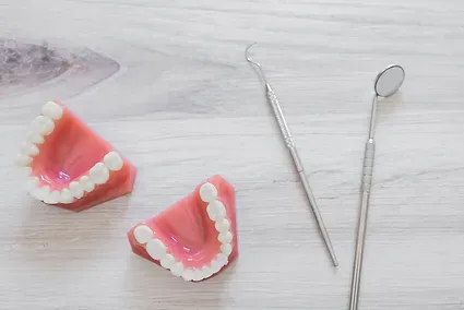 Dental models and orthodontic instruments on a light wood table