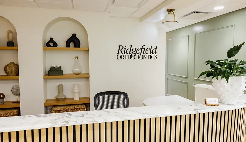 Reception desk at Ridgefield Orthodontics with arched display shelves