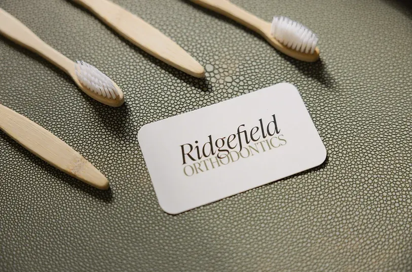 Bamboo toothbrushes around a Ridgefield Orthodontics card