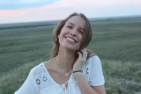 Smiling young woman after orthodontic treatment