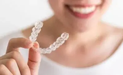 Woman holding a clear aligner