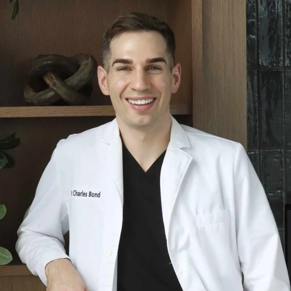 Dr. Charles Bond of Bond Orthodontics in Northbrook IL smiling in a white embroidered coat.