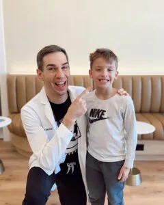 Dr. Charles Bond pointing at a smiling young patient inside the Bond Orthodontics studio.