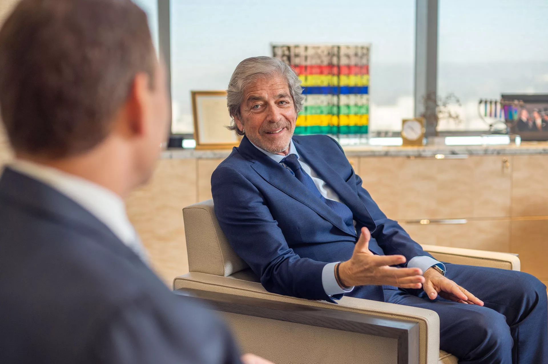 Two businessmen in a modern office engage in a conversation