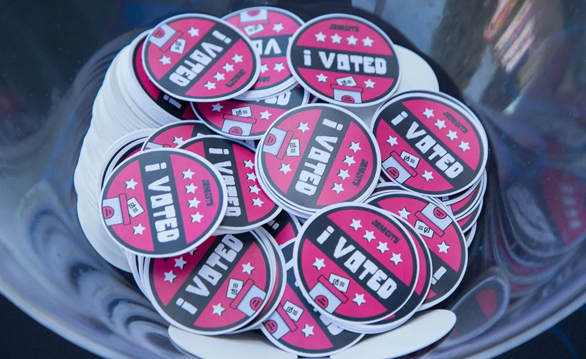 Bowl filled with red and black "I Voted" stickers with ballot box graphic