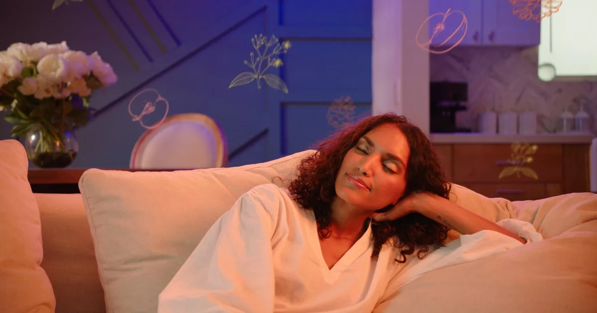 Woman relaxing on a beige sofa with floral decor in living room