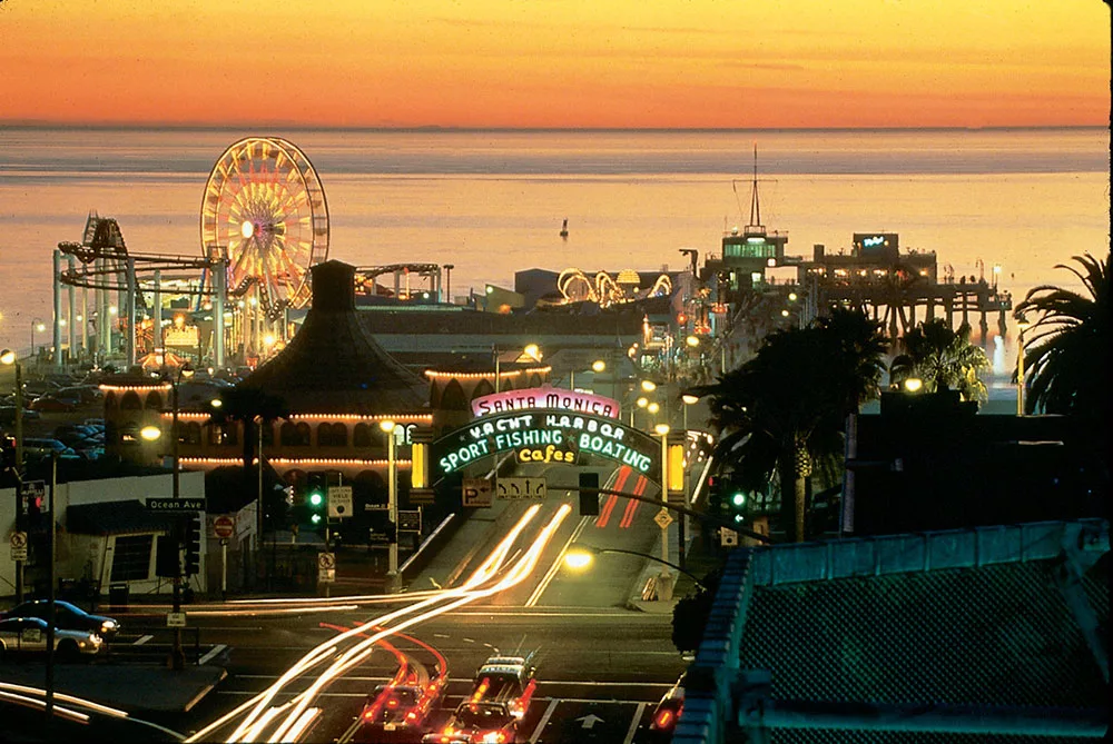 Santa Monica Pier at sunset with vibrant Ferris wheel lights