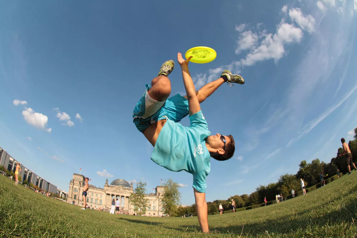 Man performs freestyle frisbee trick in a park