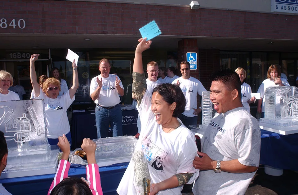 Group of people celebrating outside a building with ice sculptures