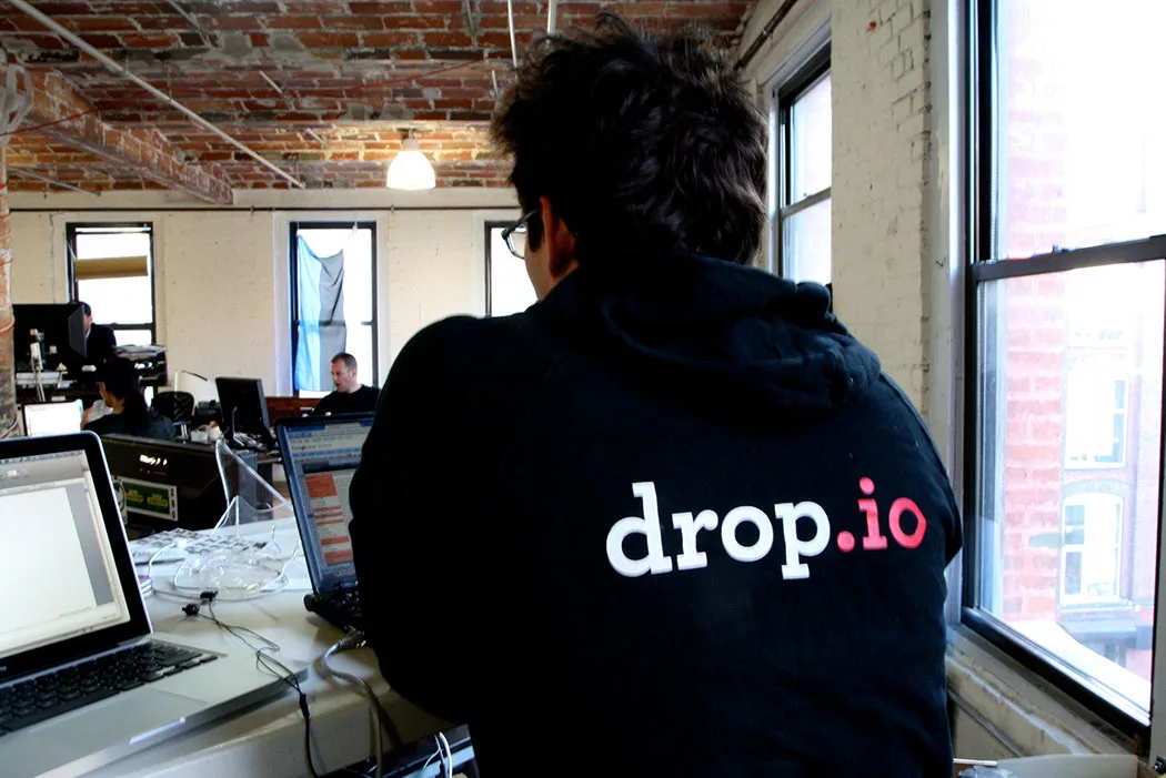Person working on a laptop in a brick loft office