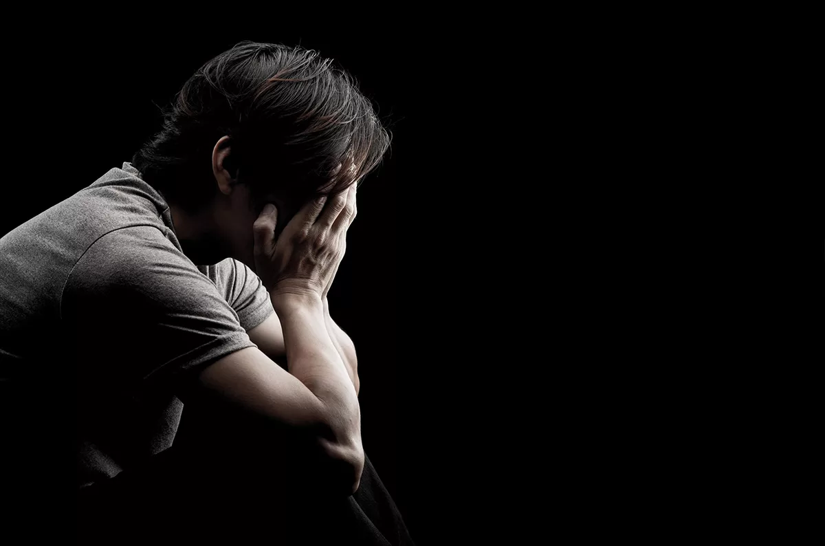 Person sitting with head in hands