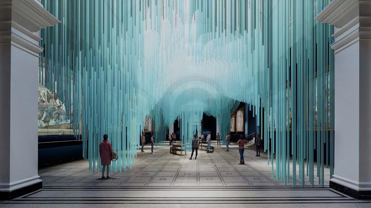People standing under a ceiling art installation of hanging blue rods in a large
