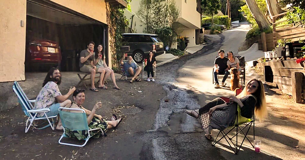 Neighbors enjoying a casual outdoor gathering on lawn chairs in a driveway