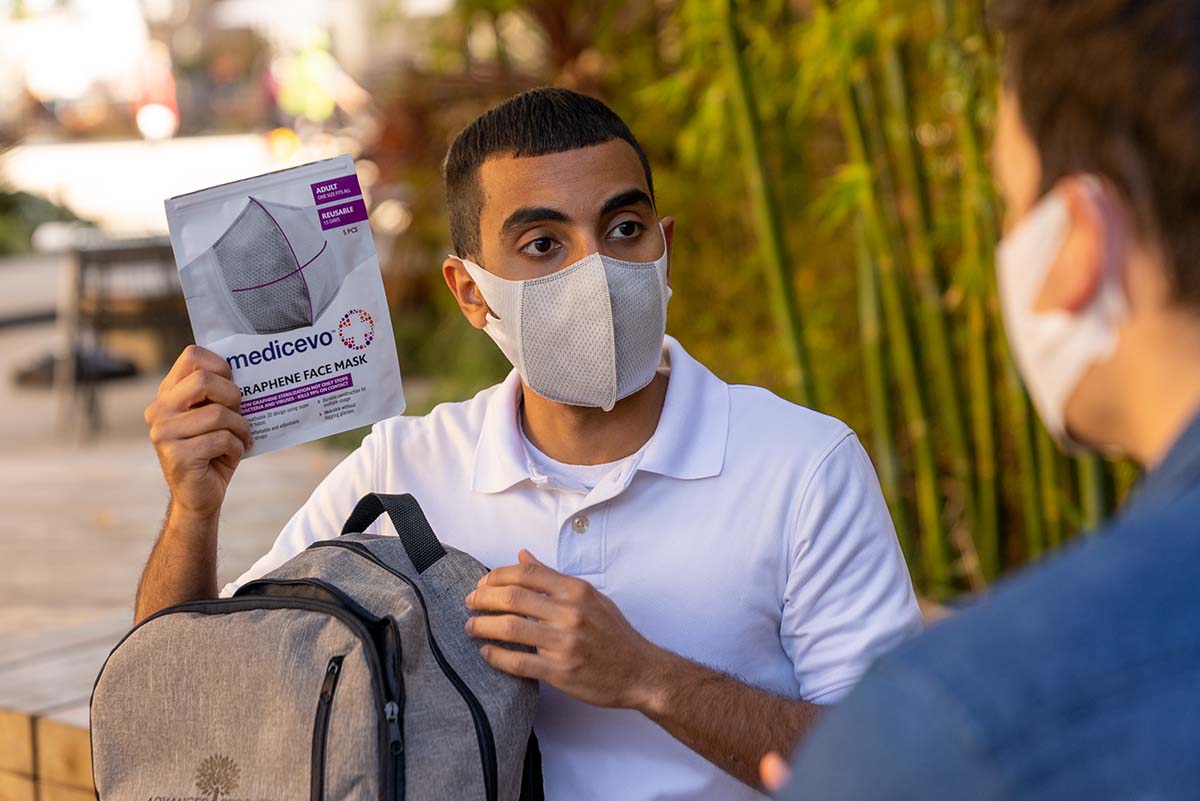 Man holding Medicevo graphene face mask packet