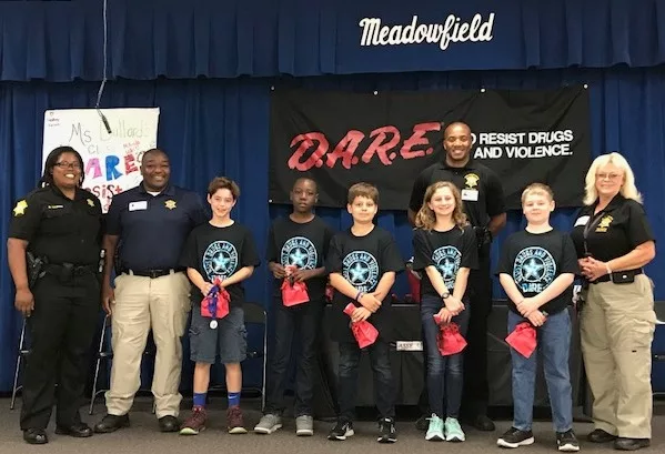 Group of students and police officers at D.A.R.E. event in Meadowfield school