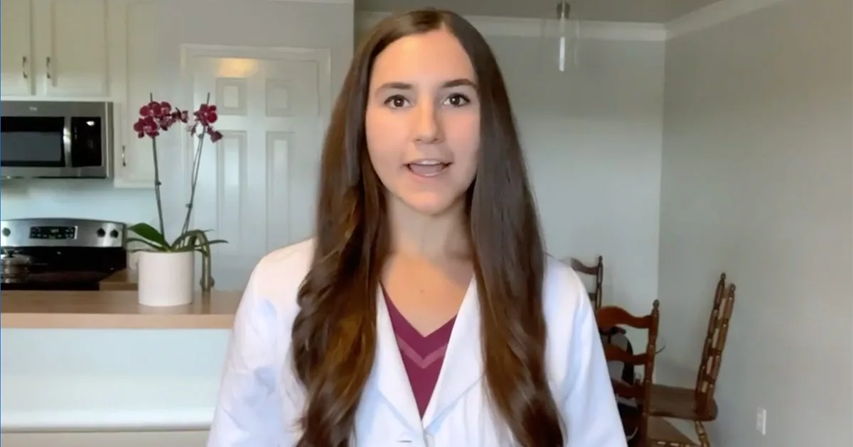 Woman in white coat speaks in a modern kitchen