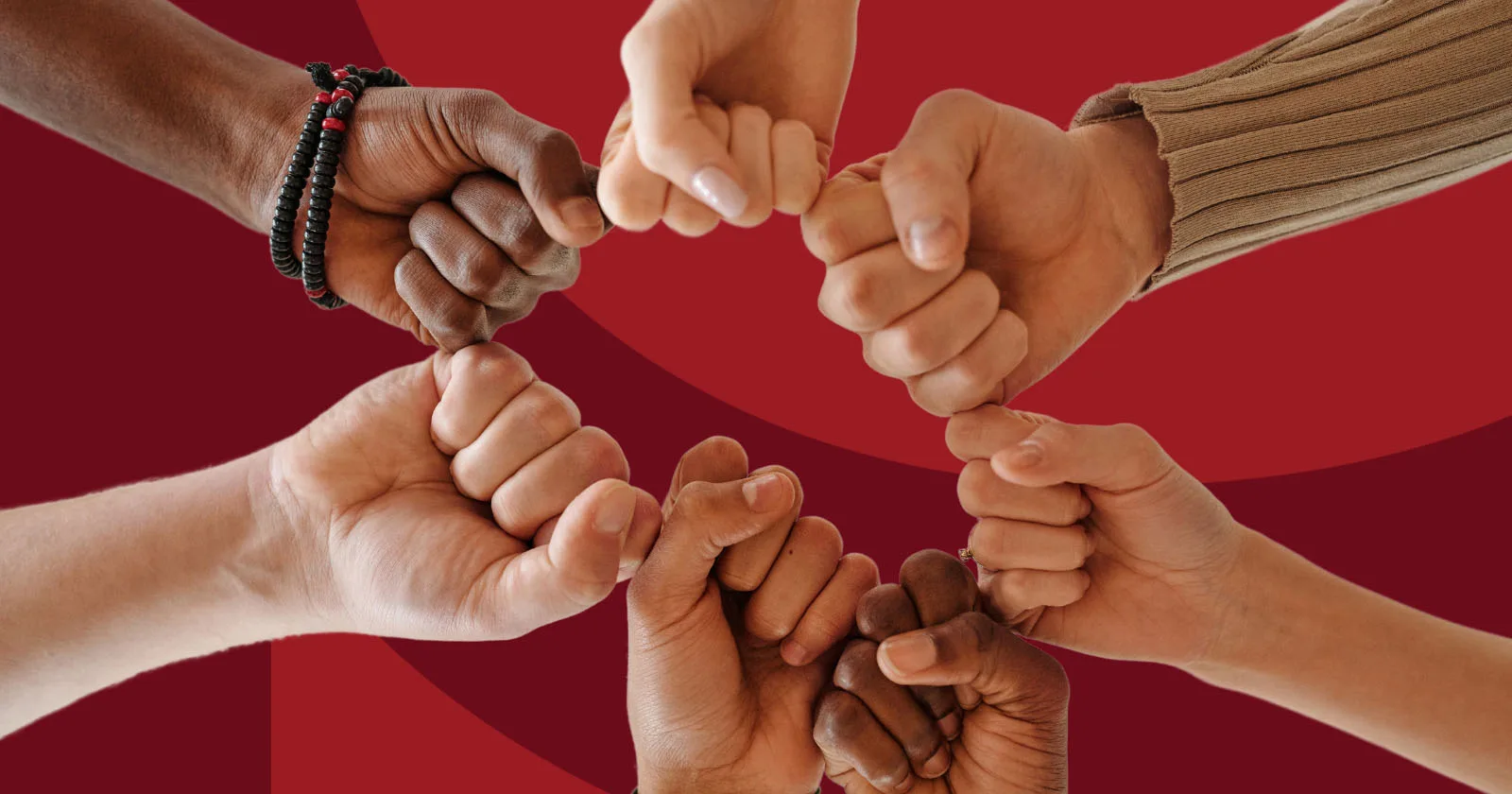 Diverse hands forming a unity circle with fist bumps against a red background