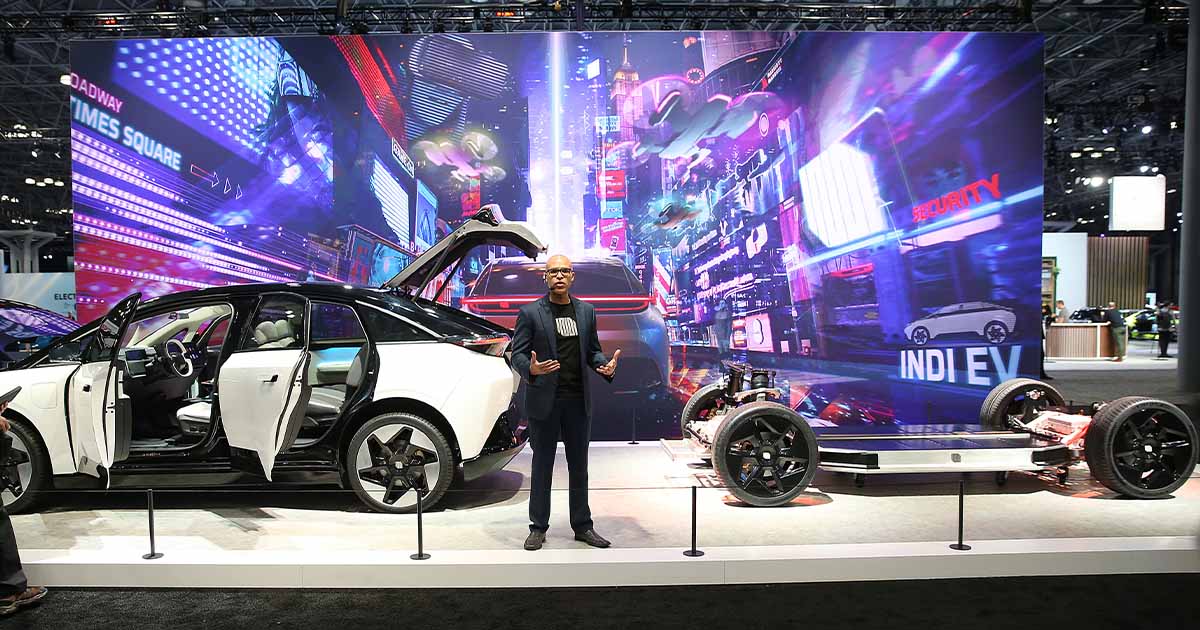 Electric car at auto show with open doors and futuristic city backdrop