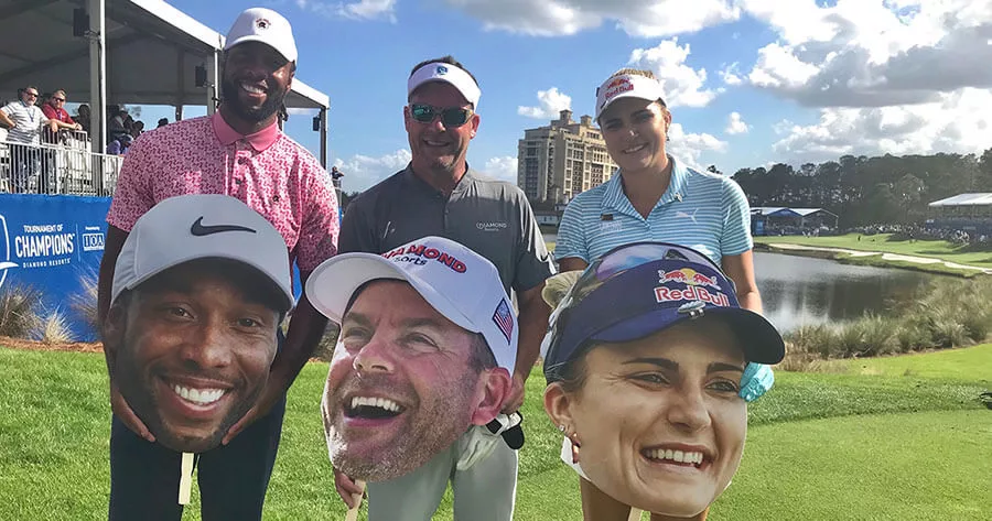 Golfers on green holding large face cutouts near clubhouse