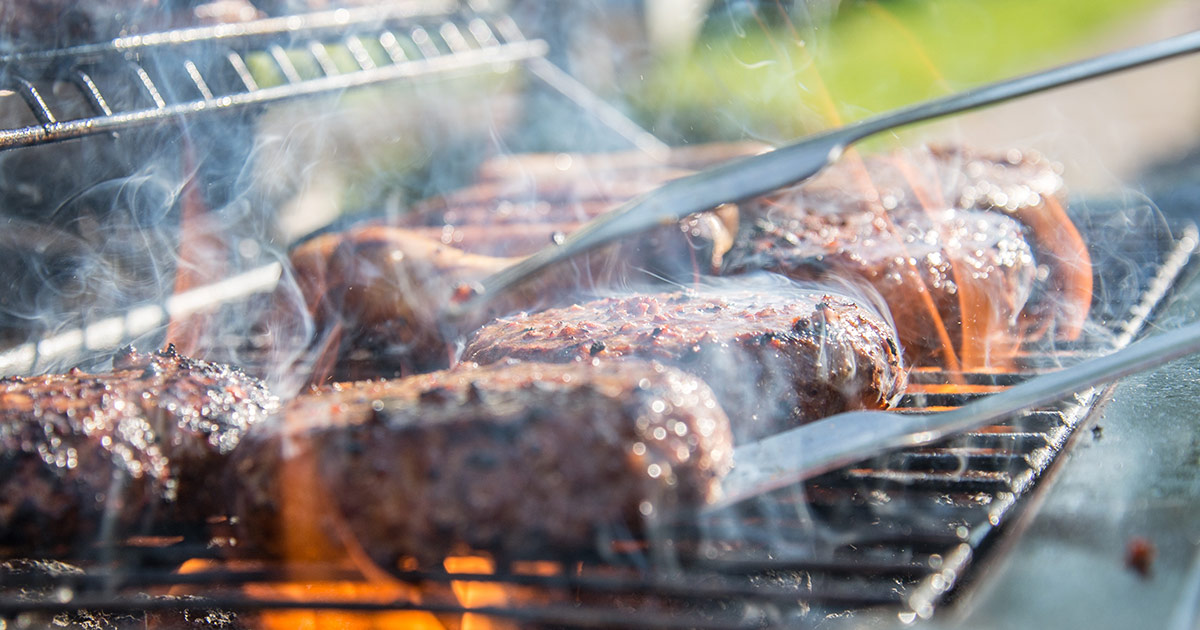 Steaks sizzling on a live fire barbecue