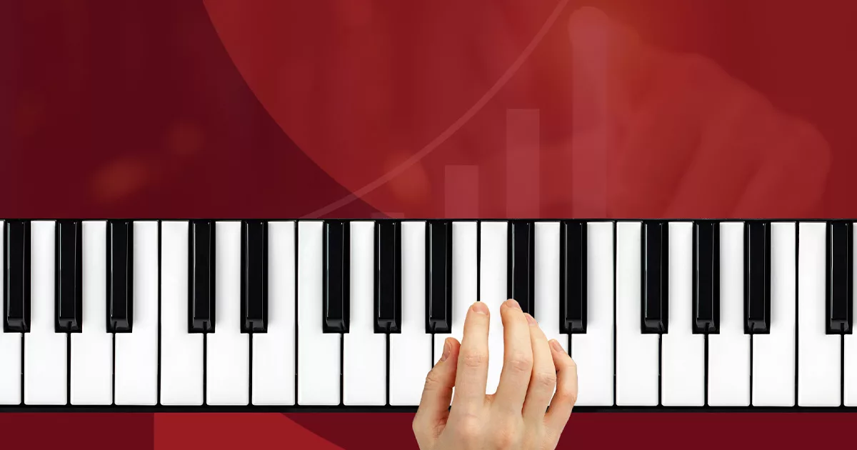 Hand playing piano keys on a red backdrop