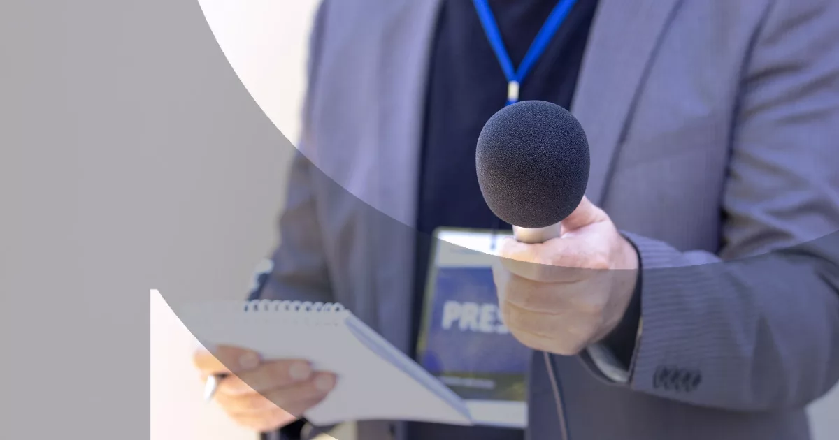 Journalist holding microphone and notepad during an interview