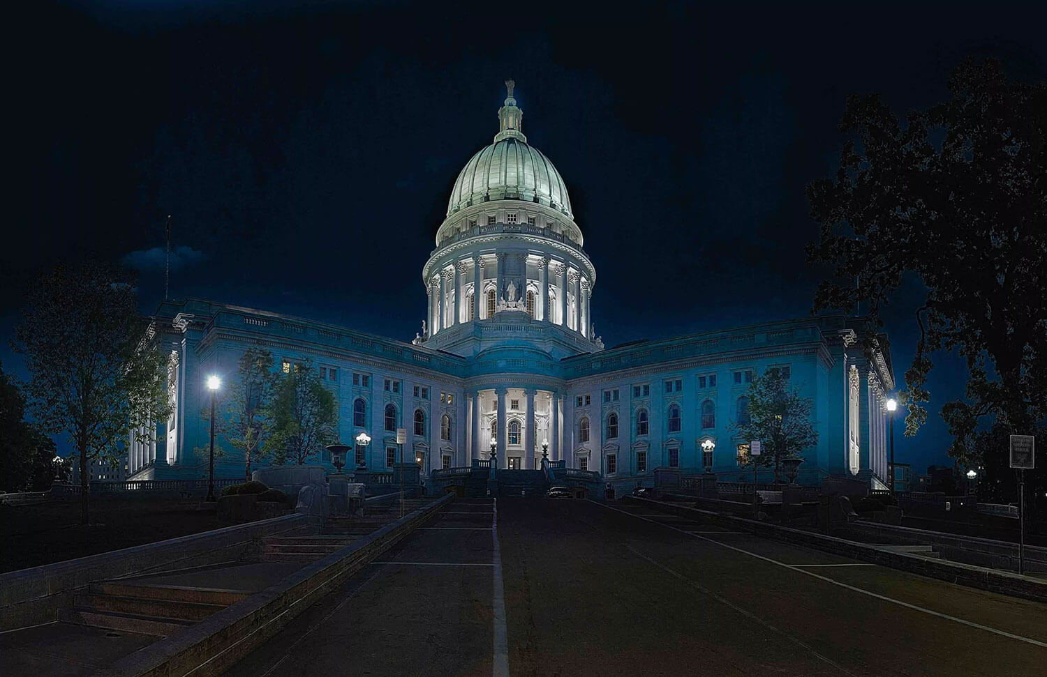 Illuminated capitol building at night with a prominent dome and neoclassical architecture
