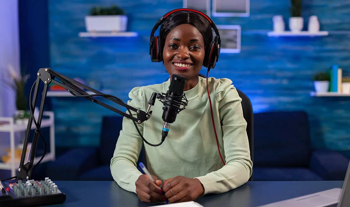 Podcaster recording in a studio with headphones and microphone