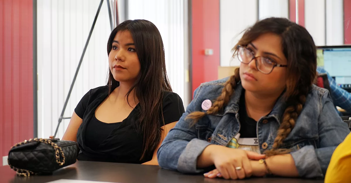 Two women attentively listening in a meeting room