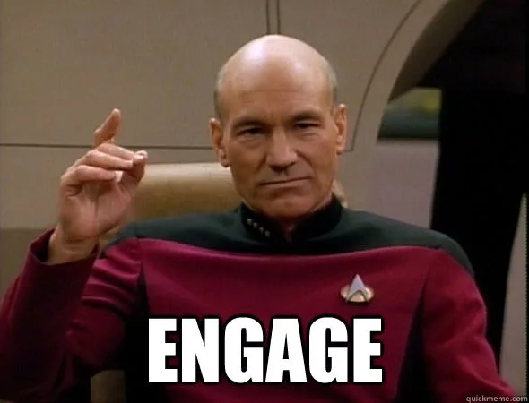 A man in a red uniform shirt sitting in a starship command chair