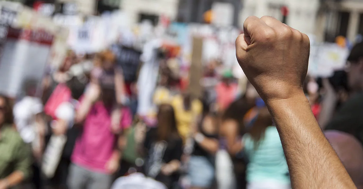 Raised fist in foreground