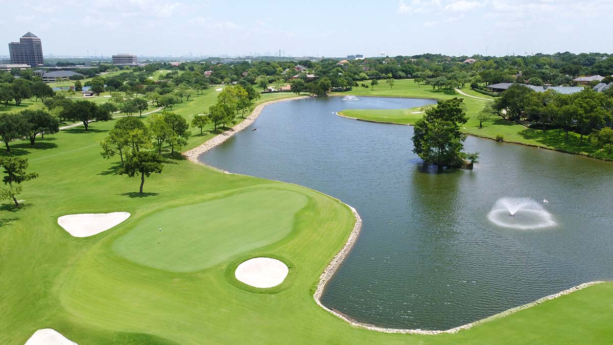 Aerial view of lush golf course with a large pond