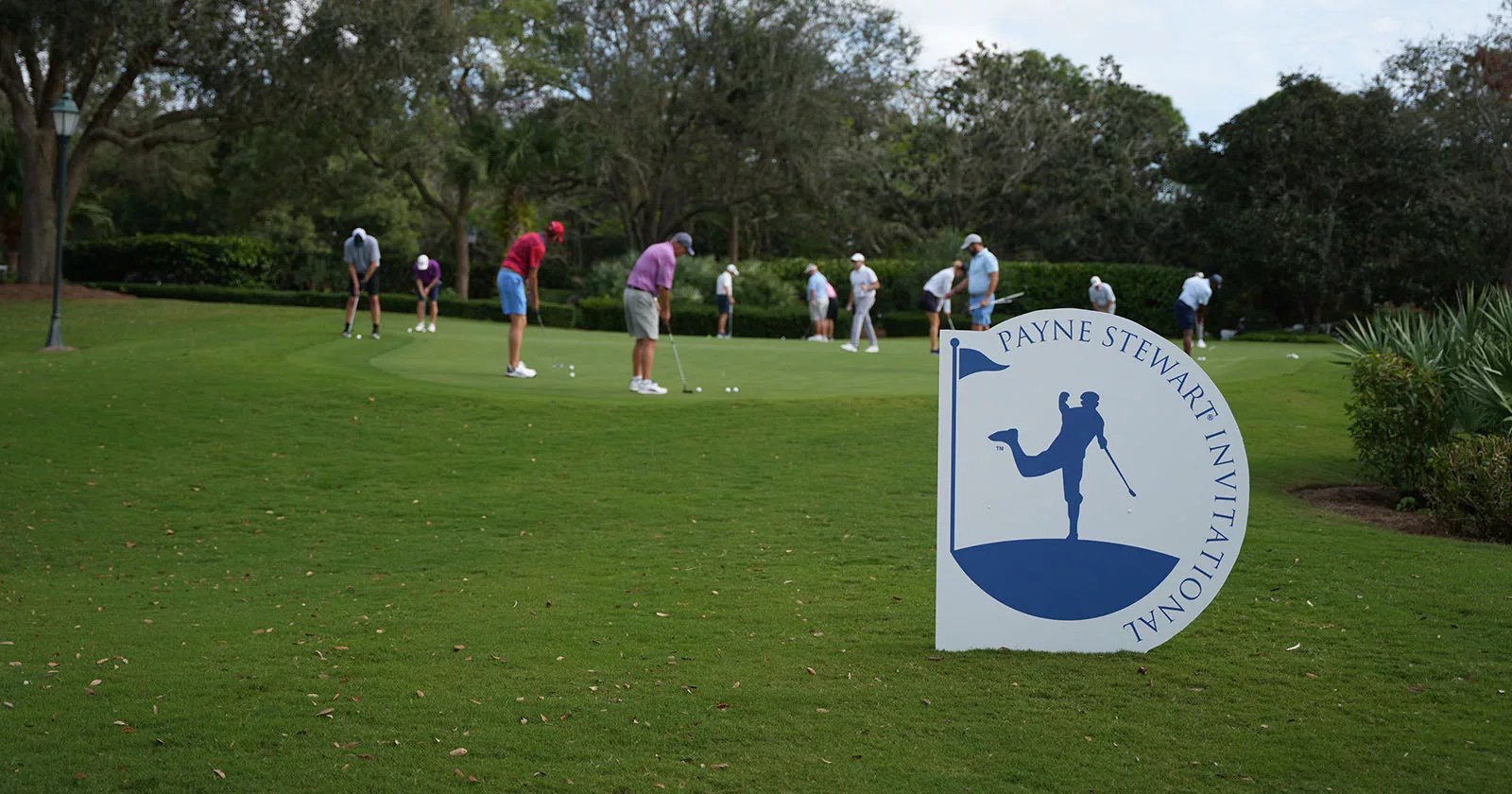 Golfers practicing putting on green at Payne Stewart Invitational