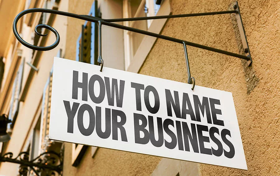 Sign reading "How to Name Your Business" hanging on a beige wall