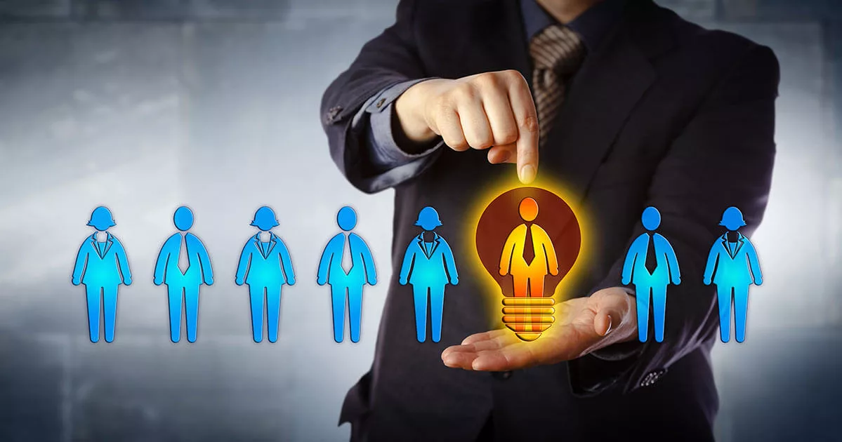 Businessman highlighting a glowing light bulb shaped like a person