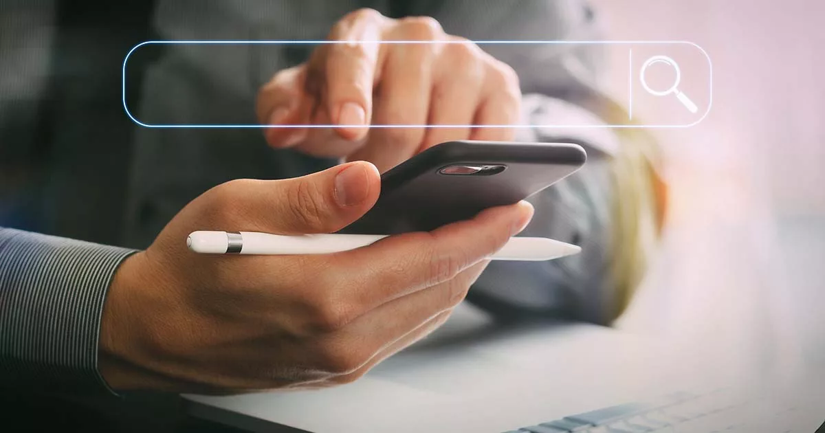 Hand holding smartphone and stylus with search bar overlay