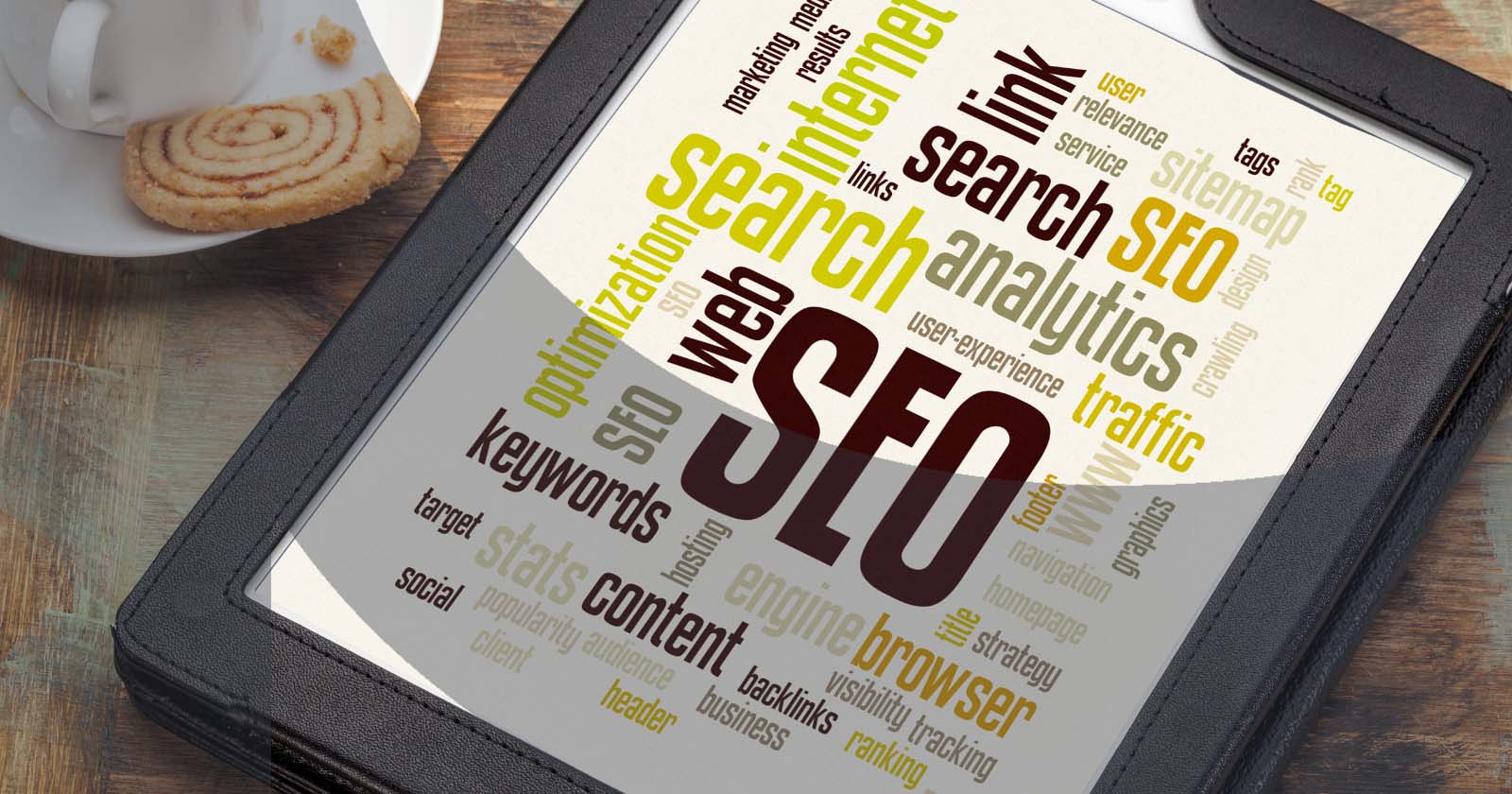 Tablet showing SEO-related word cloud with terms like analytics