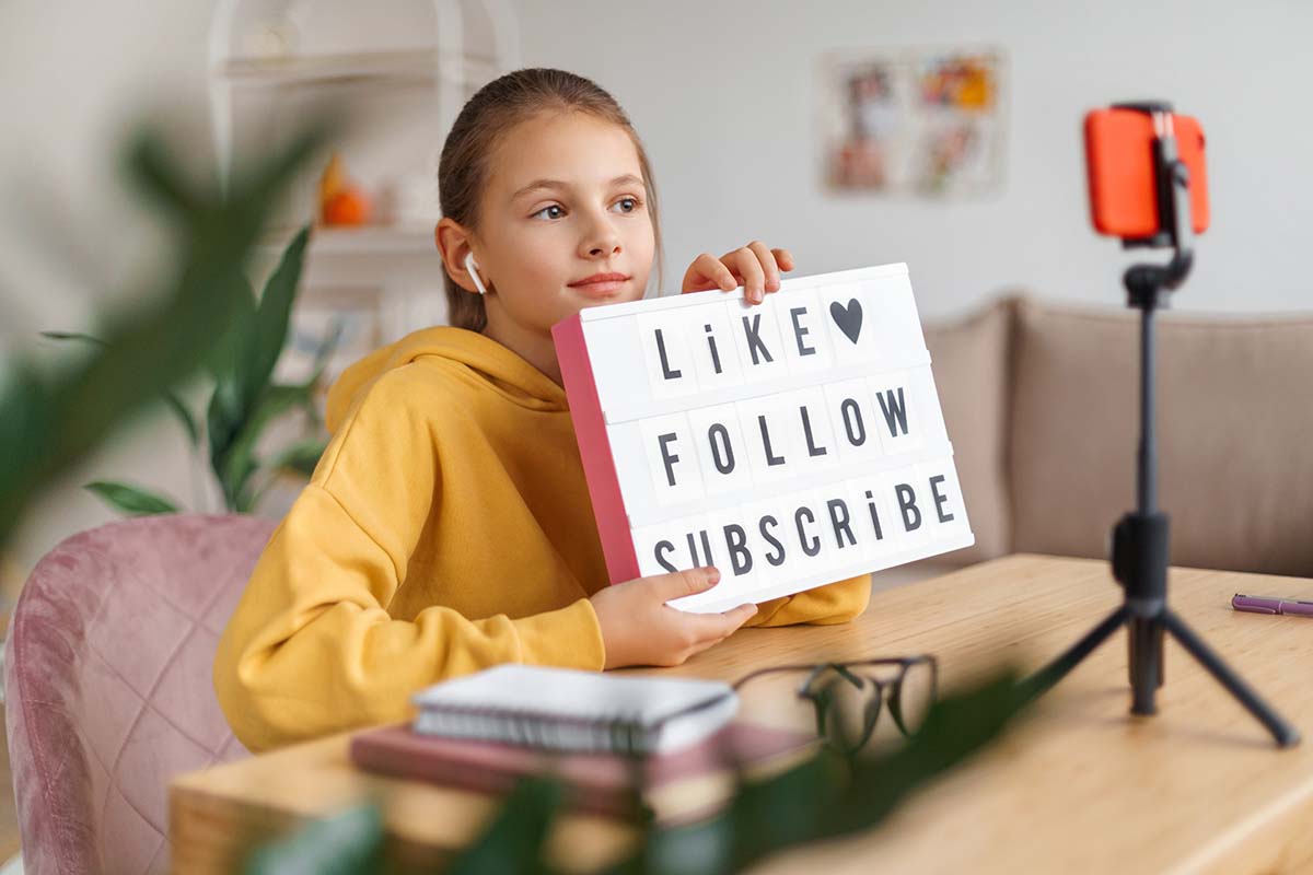 Girl holding 'Like Follow Subscribe' sign