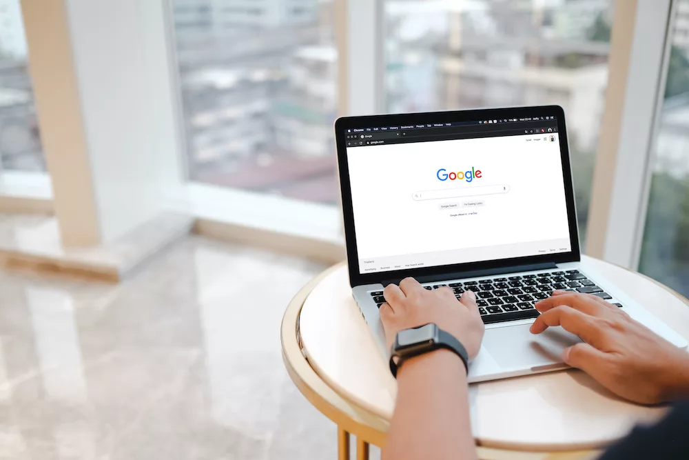 Person using a laptop with a Google search page open