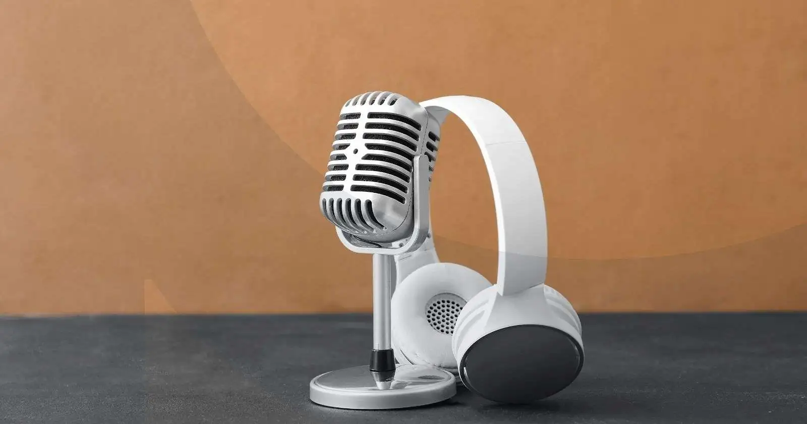 Headset leaning against microphone with brown background.