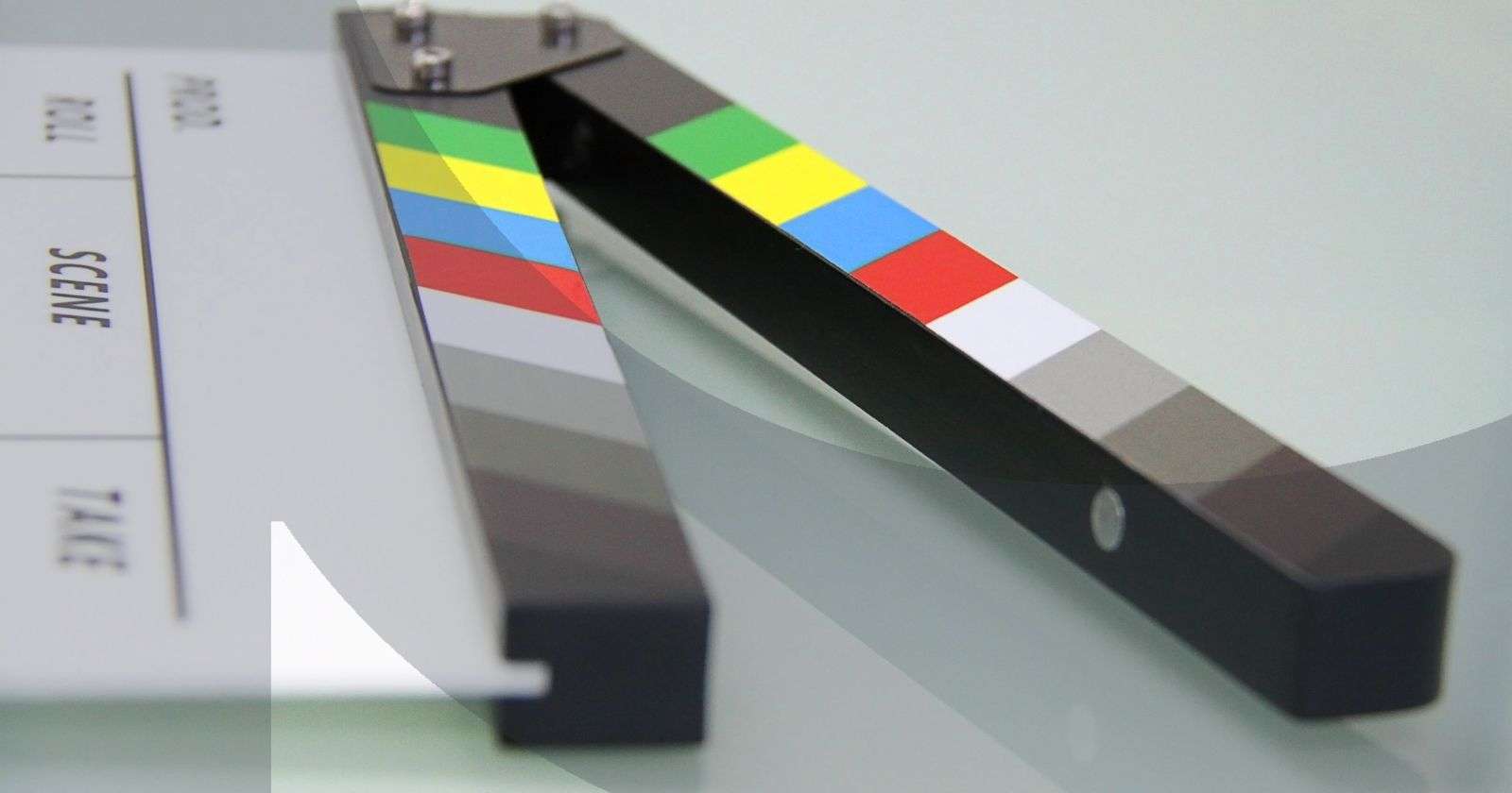 Close-up of a colorful film clapperboard on a reflective surface
